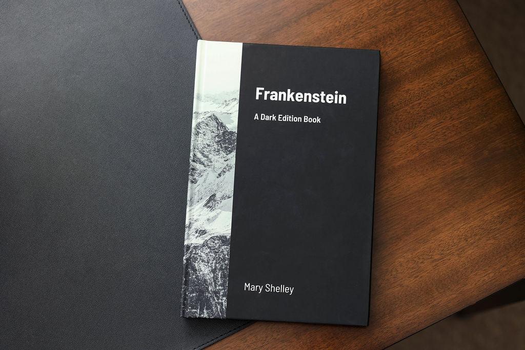 Book titled 'Frankenstein' by Mary Shelley on a wooden surface