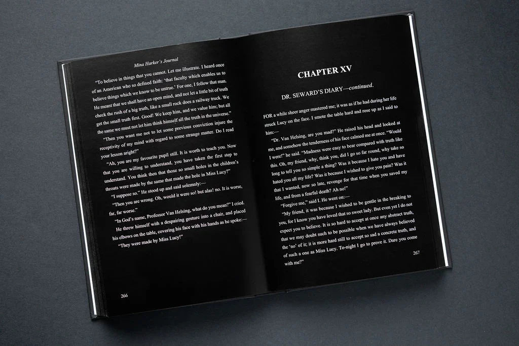 Open book showing text on black pages with a dark background