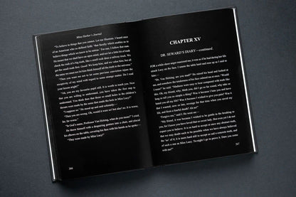 Open book showing text on black pages with a dark background