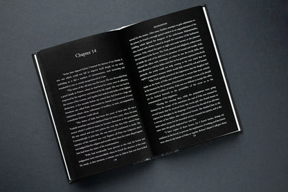 Open book with white text on a dark gray background