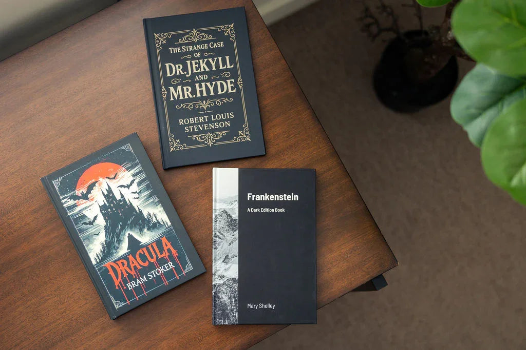 Three books on a wooden surface: 'Dracula', 'The Strange Case of Dr. Jekyll and Mr. Hyde', and 'Frankenstein'.