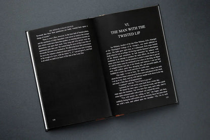 Open book with black pages and white text on a dark gray background