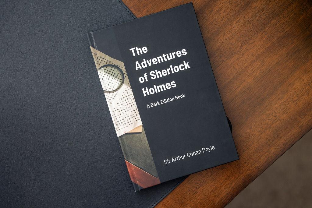 Book titled 'The Adventures of Sherlock Holmes' on a wooden surface